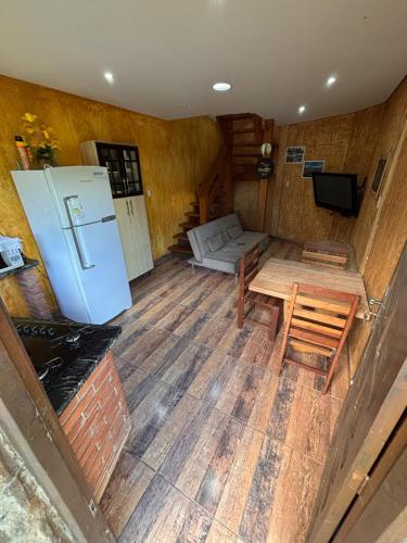 a room with a refrigerator and a table and a couch at Chácara Águas Claras in Monte Sião