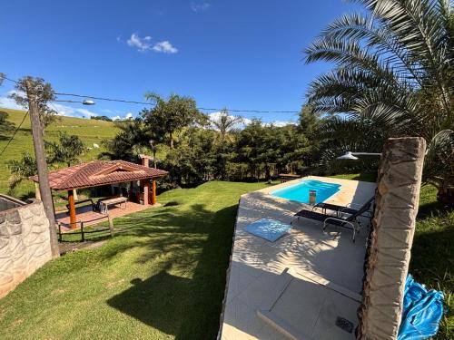 a backyard with a swimming pool and a house at Chácara Águas Claras in Monte Sião