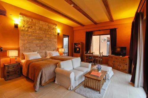 a bedroom with a bed and a couch and a tv at Toscana Hotel La Casetta in Mu Si
