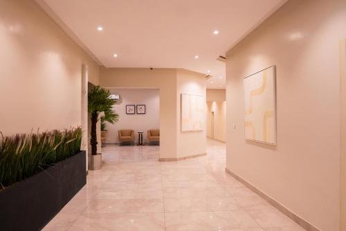 a hallway with paintings on the walls and a hallway with chairs at Porto Golf Hotels in Kano
