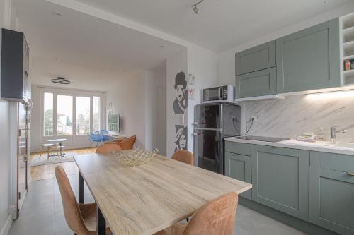 une cuisine avec une table en bois et une salle à manger dans l'établissement Les Sables, Appartement 6 personnes, à Villefranche-sur-Saône