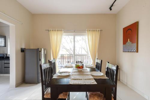 a dining room with a black table and chairs at BluO 2BHK Koramangala - Kitchen, Lift, Parking in Bengaluru