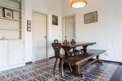 a dining room with a wooden table and a bench at Numana, villa singola con giardino e vista mare N111 in Numana