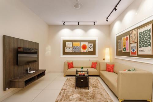 a living room with a couch and a table at BluO 2BHK Koramangala - Kitchen, Lift, Parking in Bengaluru