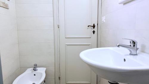 a white bathroom with a sink and a toilet at Numana, villa singola con giardino e vista mare N111 in Numana