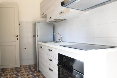 a white kitchen with a sink and a refrigerator at Numana, villa singola con giardino e vista mare N111 in Numana