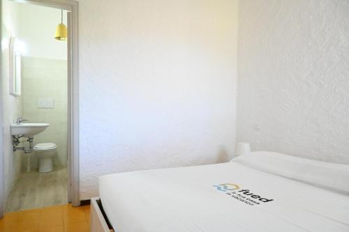 a white room with a bed and a toilet at Numana, villa singola con giardino e vista mare N111 in Numana