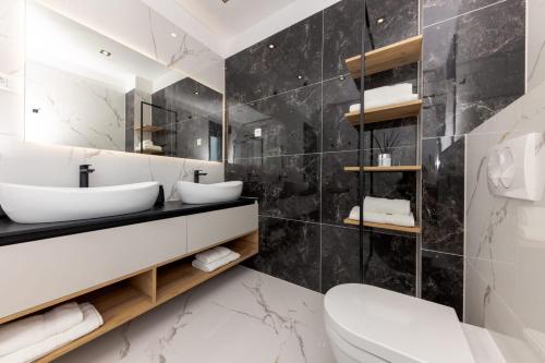 ein Badezimmer mit zwei Waschbecken und einem Spiegel in der Unterkunft Villa Vista Adriatica in Donji Seget