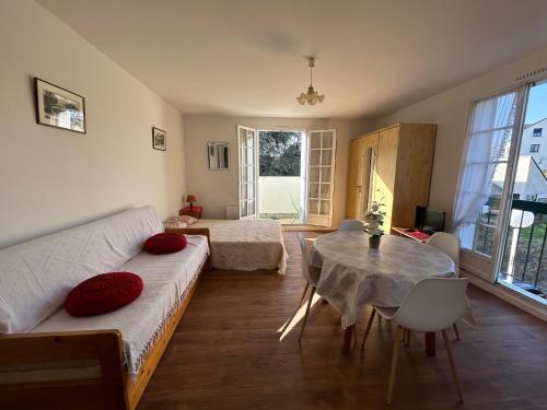 un salon avec un canapé et une table dans l'établissement Studio lumineux au centre-ville avec balcon - FR-1-541-133, à La Roche-Posay