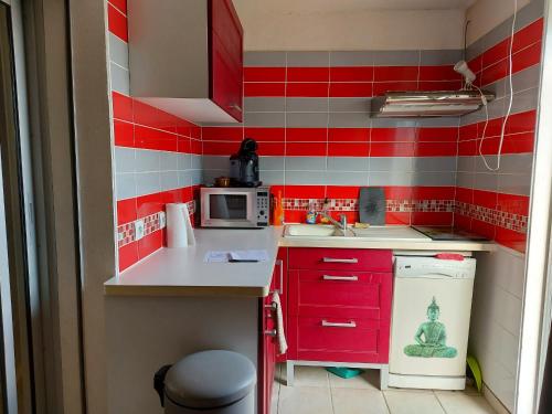 - une petite cuisine avec du carrelage rouge et blanc dans l'établissement Appartement RDC avec Terrasse, Parking et Animaux Acceptés à 100m de la Plage - FR-1-776-116, à Saint-Cyprien