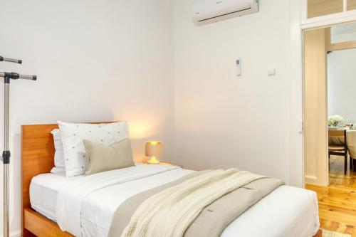 ein weißes Schlafzimmer mit einem Bett und einem Tisch in der Unterkunft Casa do Pinheiro I, a Home in Madeira in São Vicente