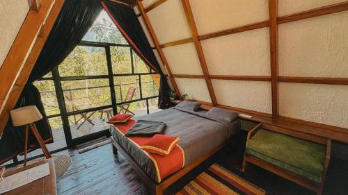 a bedroom with a bed and a window in a room at Forestscape Resort Munnar in Munnar