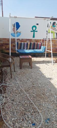 a hammock and a bench with a sign on it at ZAIN PALACe in Jazīrat al ‘Awwāmīyah