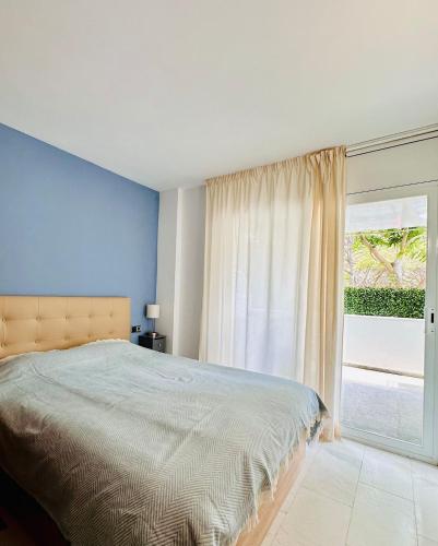 a bedroom with a bed and a large window at Seafront Apartment - Costa Brava in Blanes