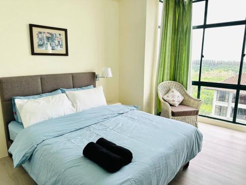 a bedroom with a bed with a black object on it at Costa Mahkota - 3 min to Mahkota, 4pax, 1car park in Melaka