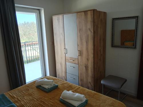 a bedroom with a bed and a dresser and a window at Apolo Apartments in Pula