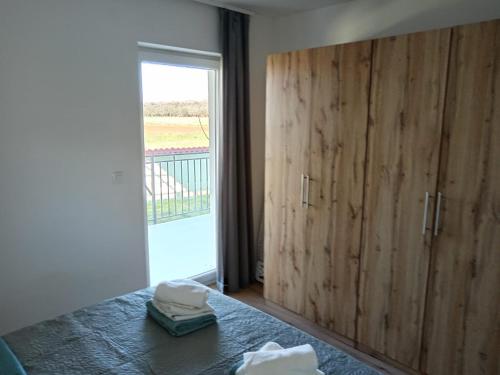 a bedroom with a large wooden cabinet and a window at Apolo Apartments in Pula