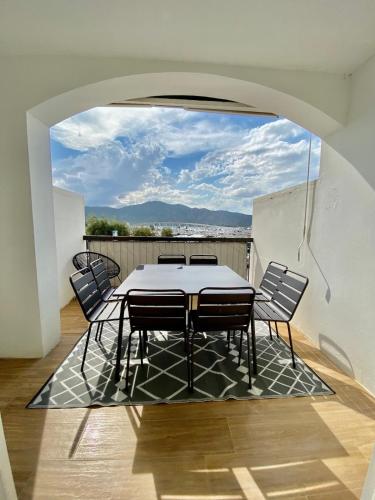 une salle à manger avec une table et des chaises sur un balcon dans l'établissement Belle vue sur le port & Parking privé, à Saint-Florent