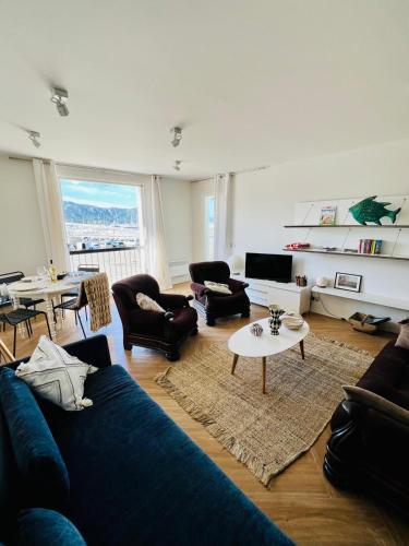 un salon avec un canapé bleu et une table dans l'établissement Belle vue sur le port & Parking privé, à Saint-Florent