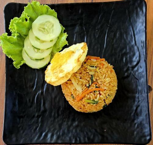 a black plate with rice and vegetables on it at Makarma Resort Lombok in Senggigi 