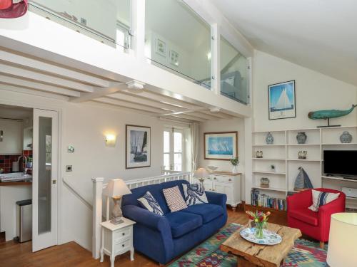 a living room with a blue couch and red chairs at Seapie Corner in Yarmouth