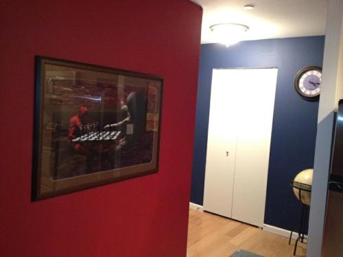 a room with a red wall with a picture on it at Bachelor Pad Oasis in Bronx