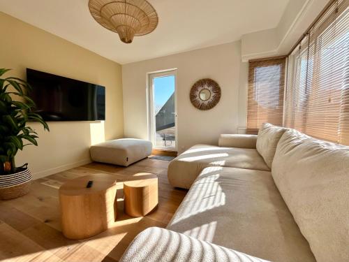 un salon avec un canapé et une télévision dans l'établissement Villa familiale vue mer, à Dunkerque