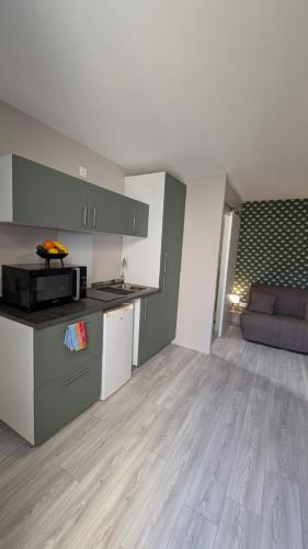 une cuisine et un salon avec un canapé dans une pièce dans l'établissement Studio - La Baume au coeur, à Sisteron