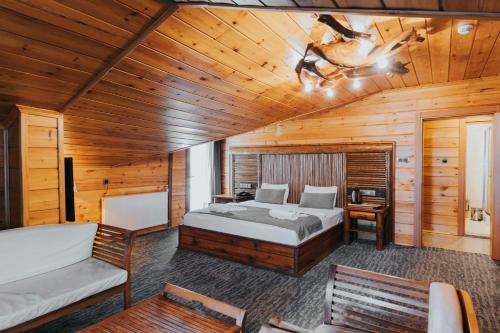 a bedroom with a bed in a wooden cabin at Inan Kardesler Hotel in Uzungöl
