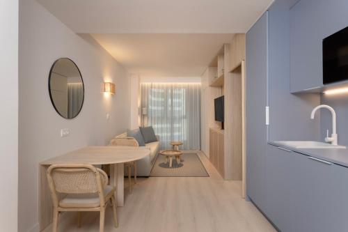 a kitchen and living room with a table and a sink at Staybridge Suites & Apartments Malaga by IHG in Málaga