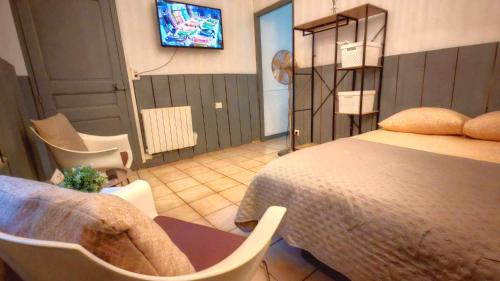 une chambre avec un lit et une télévision au mur dans l'établissement Perpignan La Catalane, à Perpignan