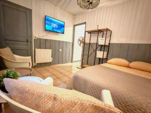 une chambre avec un lit et une télévision au mur dans l'établissement Perpignan La Catalane, à Perpignan