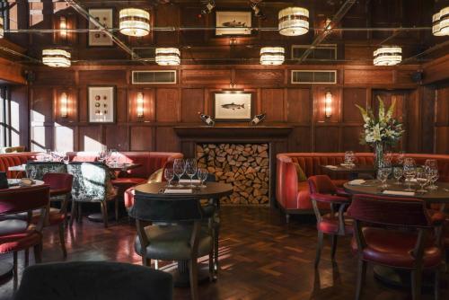 a restaurant with tables and chairs and a fireplace at Crazy Bear Stadhampton in Stadhampton