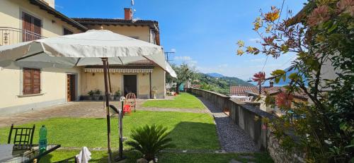 a patio with an umbrella in front of a house at la casa dell'uva in Monte Isola
