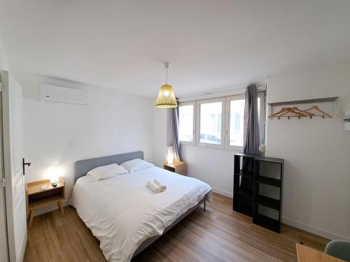 une chambre avec un lit blanc et une fenêtre dans l'établissement Naples - Studio centre-ville, à Reims