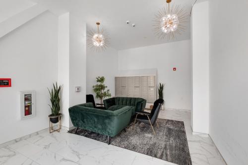a living room with a green couch and a chair at Urban Retreat Studio - Balcony Smart Design in Philadelphia