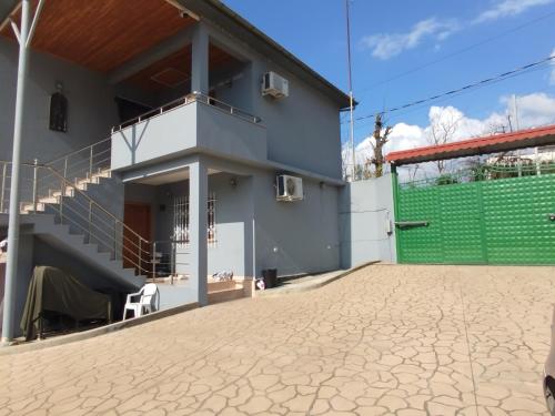 a house with a green gate and a patio at Villa Miceli in Tirana