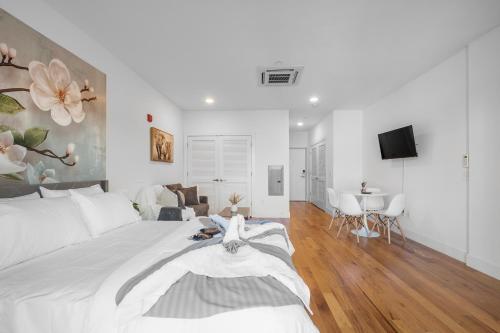 a white bedroom with a large bed and a living room at Skyline Studio - Modern Comfort Pool Access in Philadelphia