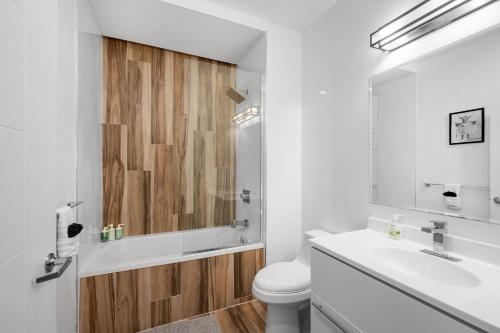 a white bathroom with a toilet and a sink at Skyline Studio - Modern Comfort Pool Access in Philadelphia