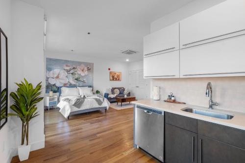 a kitchen and living room with a couch in the background at Skyline Studio - Modern Comfort Pool Access in Philadelphia
