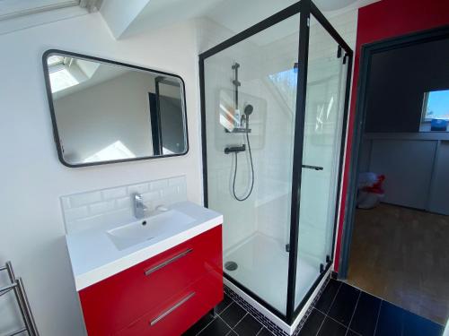 La salle de bains est pourvue d'un lavabo rouge et d'une douche. dans l'établissement Une belle chambre au calme avec piscine, à Ormesson-sur-Marne
