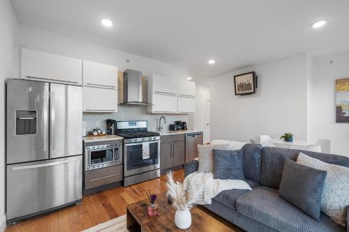 a living room with a couch and a kitchen at Luxury 1BR Loft - Skyline Views Pool Access in Philadelphia