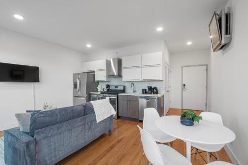 a living room and kitchen with a couch and a table at Luxury 1BR Loft - Skyline Views Pool Access in Philadelphia