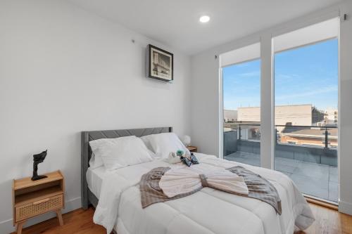 Un dormitorio blanco con una cama y una ventana grande. en Courtyard Studio Serene Space Gym Wi-fi, en Filadelfia