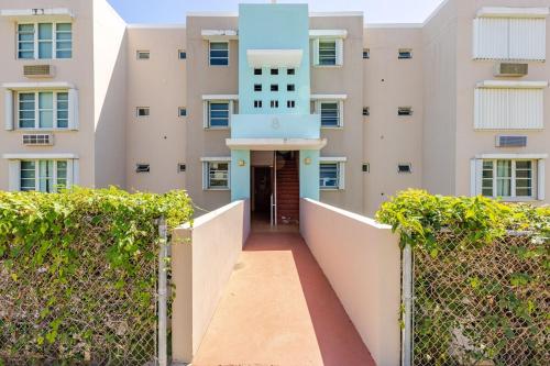 a hallway leading to a building with a blue door at Sunrise in Villas del Faro in Emajagua