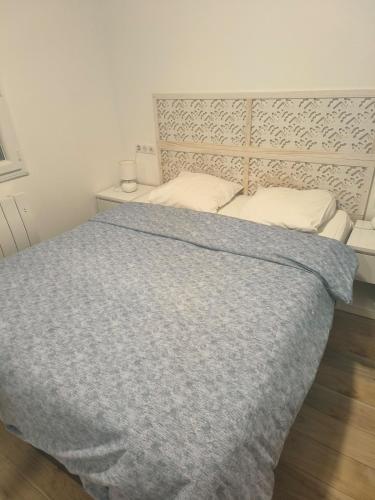 une chambre avec un lit avec une couette bleue dans l'établissement Maison MANGUELI - Bassin d 'Arcachon, à Audenge