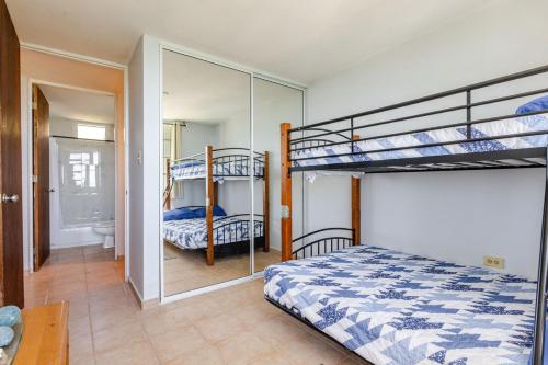 a bedroom with two bunk beds and a bathroom at Sunrise in Villas del Faro in Emajagua