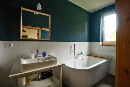 a bathroom with a tub and a sink and a bath tub at Gut Zahren in Gallin