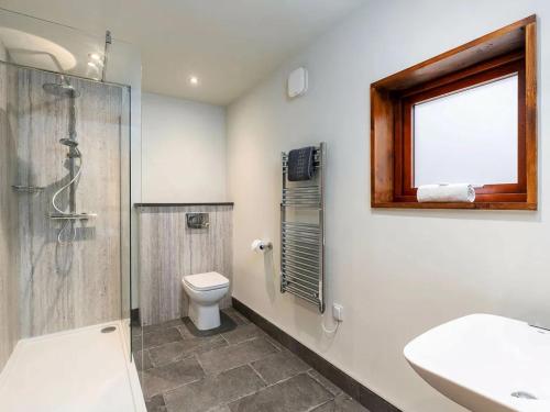 a bathroom with a shower and a toilet and a window at Strathyre, Ben Ledi Cabins - Forest Holidays in Callander