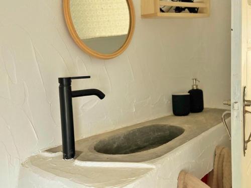 a bathroom sink with a faucet and a mirror at Casa Verde Oliva Alentejo in Alandroal